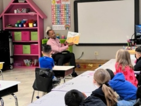 Montay Calloway reading a book to a class of children